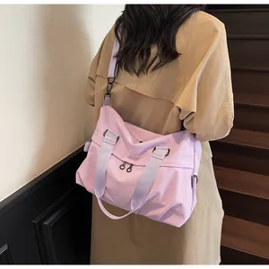 Lavender nylon tote bag with adjustable strap shown from a side view on a female model