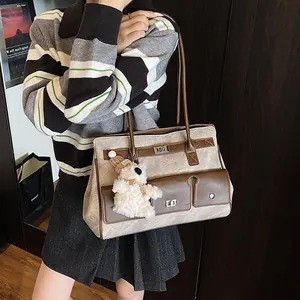Oatmeal textured tote bag with brown leather trim and cute plush bear charm