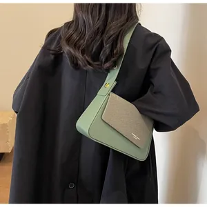 Detail of green shoulder bag featuring flap texture contrast and gold metal hardware
