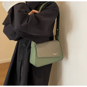 Close-up of bean green leather shoulder bag with texture detail and fashion embossing