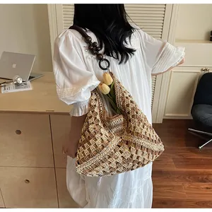 Detail of woven tote bag featuring dark brown wooden bead strap and metal ring connectors