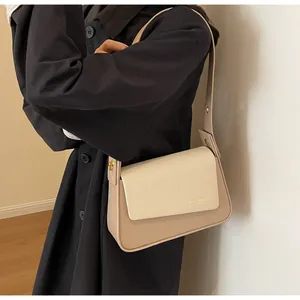 Detailed shot of the textured fabric and beige leather patchwork on the shoulder bag