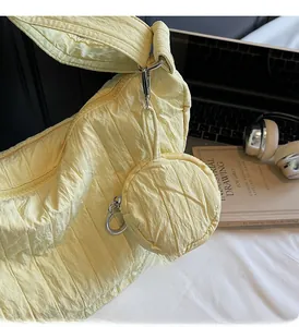 Close-up of light yellow quilted hobo bag with a matching small round coin purse charm