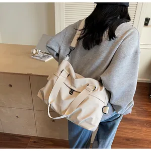 Off-white nylon crossbody bag shown with laptop and books in a modern home office setting