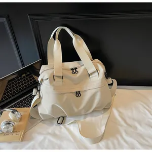 Macro view of beige nylon travel bag with dual ring zippers and large front pocket