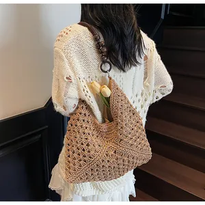Detail of woven tote bag strap featuring round wooden beads and metallic rings
