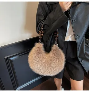 Detail of a brown plush half-moon handbag featuring a unique dark beaded handle design