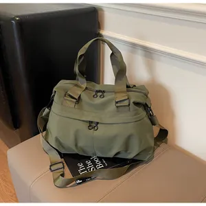 Detail of army green nylon travel bag with dual handles and adjustable shoulder strap