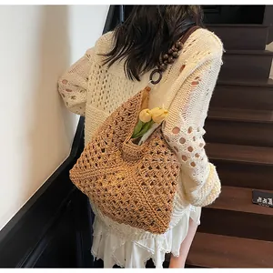 Detail of woven straw tote bag featuring wooden bead straps and tulip embellishment