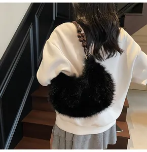 Detail of black faux fur crescent bag with decorative dark brown wooden bead strap