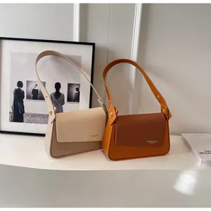 Detail of leather and textured fabric small square bags in beige and orange brown hues