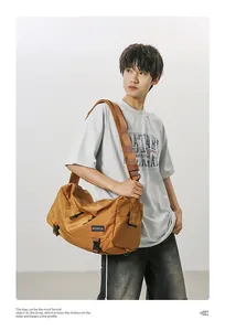 Detailed view of brown crossbody bag with adjustable strap and brand logo label