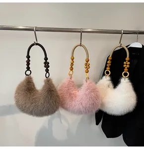 Three plush faux fur moon bags in coffee, pink, and white with beaded woven handles