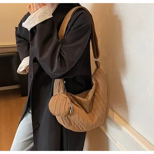 Detail view of brown pleated canvas crossbody bag with a round zip coin purse accessory