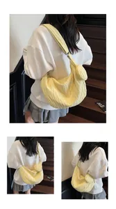 Detail of light yellow pleated tote bag showing the texture and matching mini pouch