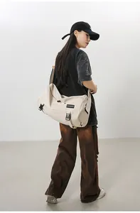 Detail view of large beige crossbody bag with MINGDAILO logo and black buckle closure