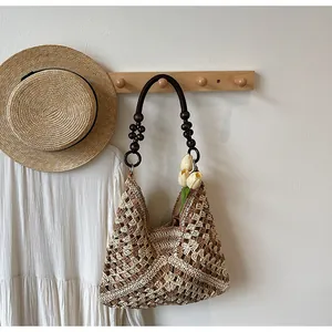 Detailed macro of the hand-woven patchwork straw tote with wooden bead handles and floral lining