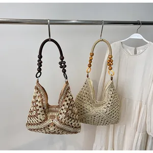 Detail of bohemian woven tote bag showing brown color blocking and wooden bead accents
