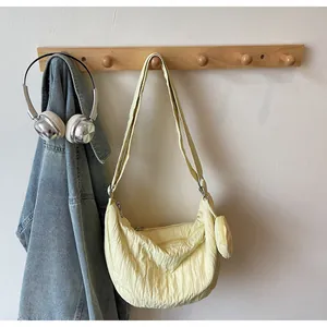 Detail of light yellow pleated fabric shoulder bag with detachable round coin purse