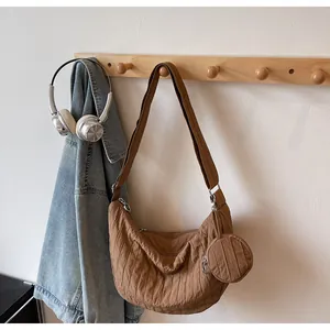 Detail of caramel crescent pleated tote with wide shoulder strap and round mini pouch