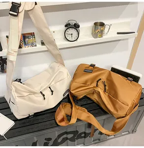Detail view of large nylon crossbody bags in cream and tan colors with adjustable straps