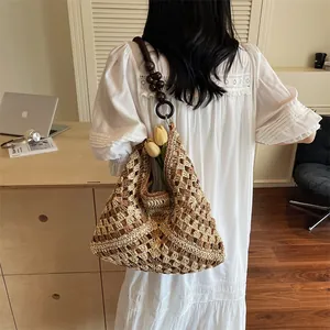 Large woven tote bag with wooden bead shoulder strap in a minimalist summer style