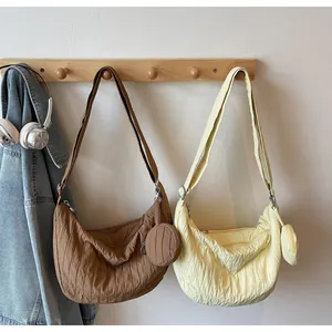 Detail showing pleated canvas moon bag with matching coin purse and adjustable strap