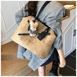 Detailopname van een grote kaki suède tote bag met een schattige teddybeer hanger