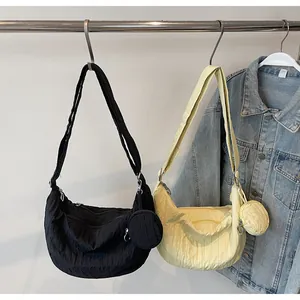Detailed shot of crescent shoulder bags with pleated texture and small round coin purse