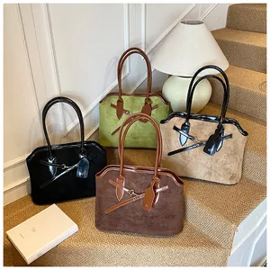 Vier elegante suède shopper tassen in zwart, olijf, camel en bruin op trappen