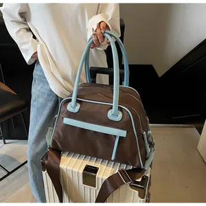 Nylon travel bag with trolley sleeve on luggage showing blue handles and strap detail
