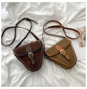 Vista detallada de bolsos bandolera retro de ante en marrón oscuro y verde oliva con hebillas