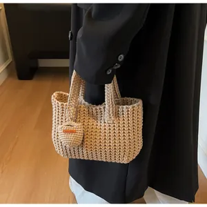 Détail d'un sac cabas au crochet kaki avec texture gaufrée et breloque coeur Hand Made