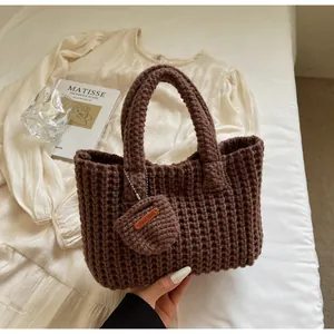 Vue détaillée du sac cabas marron tricoté à la main avec un petit charme artisanal