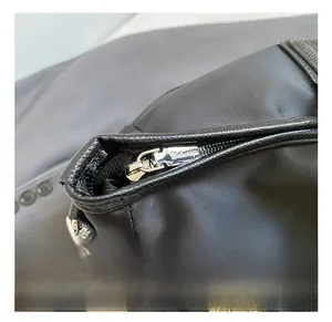 Macro shot of durable silver zipper and D-ring buckle on black Oxford travel bag