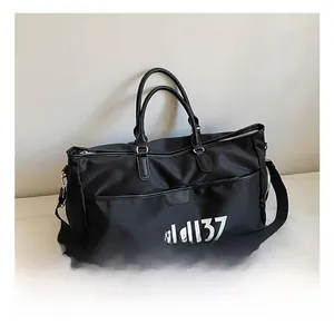 Detail of black nylon travel bag featuring leather zipper flap and mddl37 printed logo