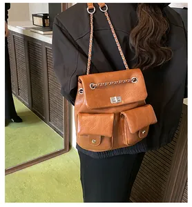 Detailed view of brown vintage textured leather backpack with chain straps and dual front pockets