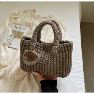 Gros plan détaillé du sac cabas au crochet marron foncé avec étiquette en cuir fait main