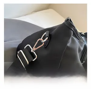 Detail show of silver metal hooks and adjustable buckle on black travel bag strap
