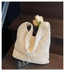 Detailed close-up of beige crochet tote bag with hollow woven pattern and fabric lining