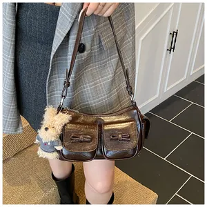 Detail of dark brown retro shoulder bag with bow accents and plush puppy charm