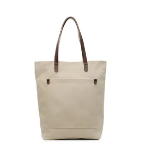 Minimalist beige canvas tote bag with brown leather handles for daily commute