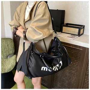Close-up of a large black Oxford travel bag with white lettering held by a model