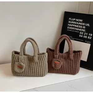 Détail de sacs à main tricotés main en kaki et marron avec porte-monnaie ronds et étiquettes