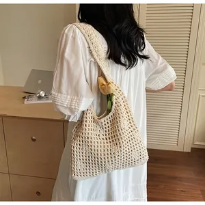 Close-up detail of cream crochet knit shoulder bag with intricate hollow mesh texture
