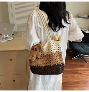 Detail of hand-woven hollow knit tote bag with gradient color texture and cute bear charm