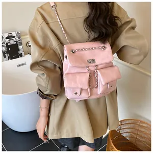 Close-up of pink faux leather backpack featuring silver twist lock and chain strap details