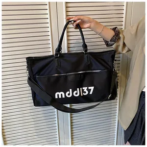 Close-up of large black Oxford cloth travel bag with white mddl 37 print and durable handles