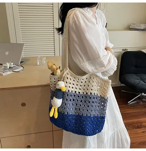 Detail of hand-woven striped beach bag with white duck charm and tulip decor