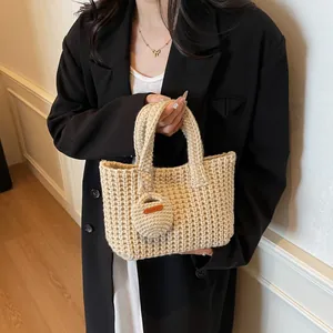 Sac fourre-tout fait main en maille épaisse beige crème avec un charm rond décoratif